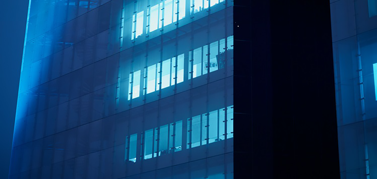 Byggnad med blått datorljus som lyser från fönstren