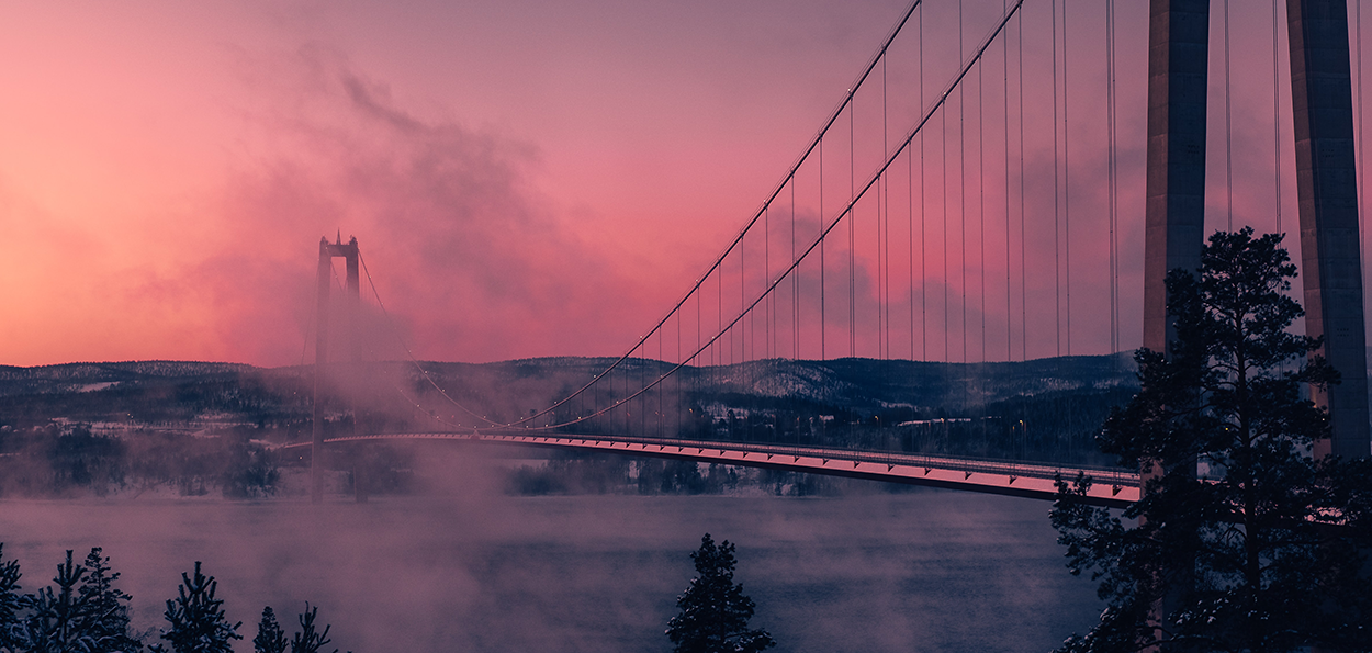 Bro mellan stad och land i solnedgång